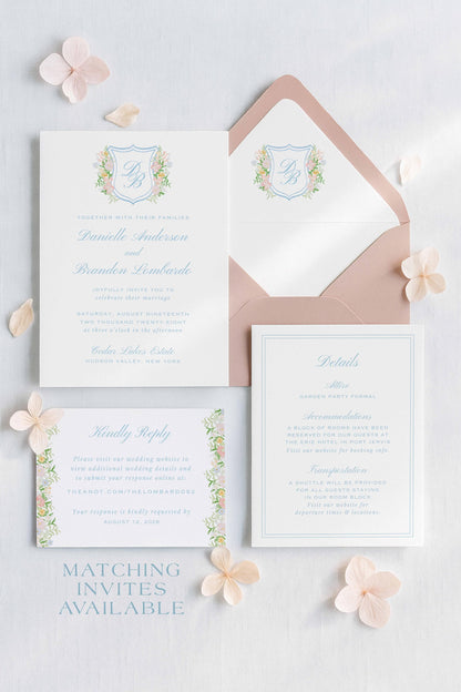 a wedding invitation set against a white background, with a matching envelope and a small card.