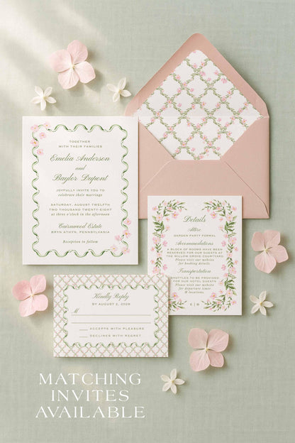 a wedding invitation set against a light green background, with pink flowers scattered around it.