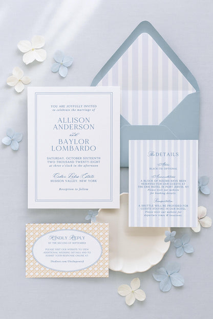 a wedding invitation with a white background and blue and white striped envelope, along with some additional wedding details and a small card.