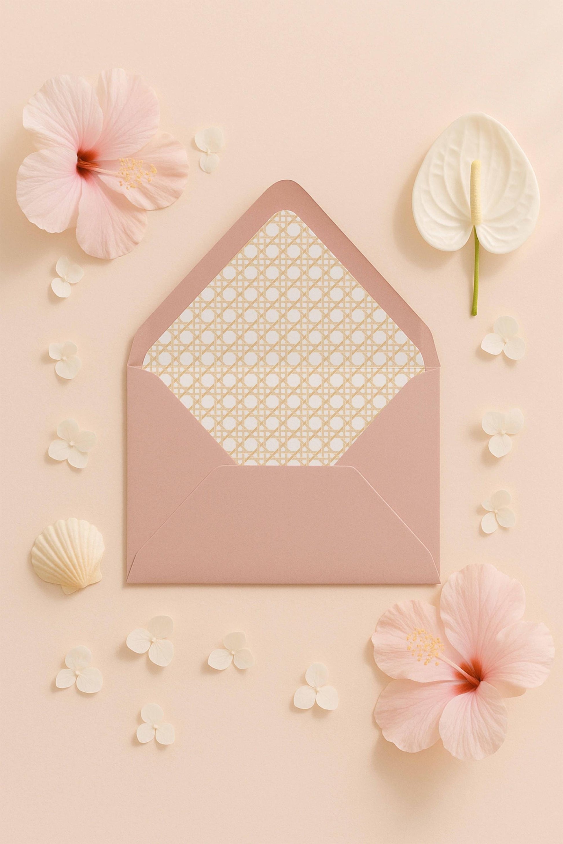 a pink envelope with a patterned paper inside, surrounded by pink flowers and small white flowers on a light peach background.