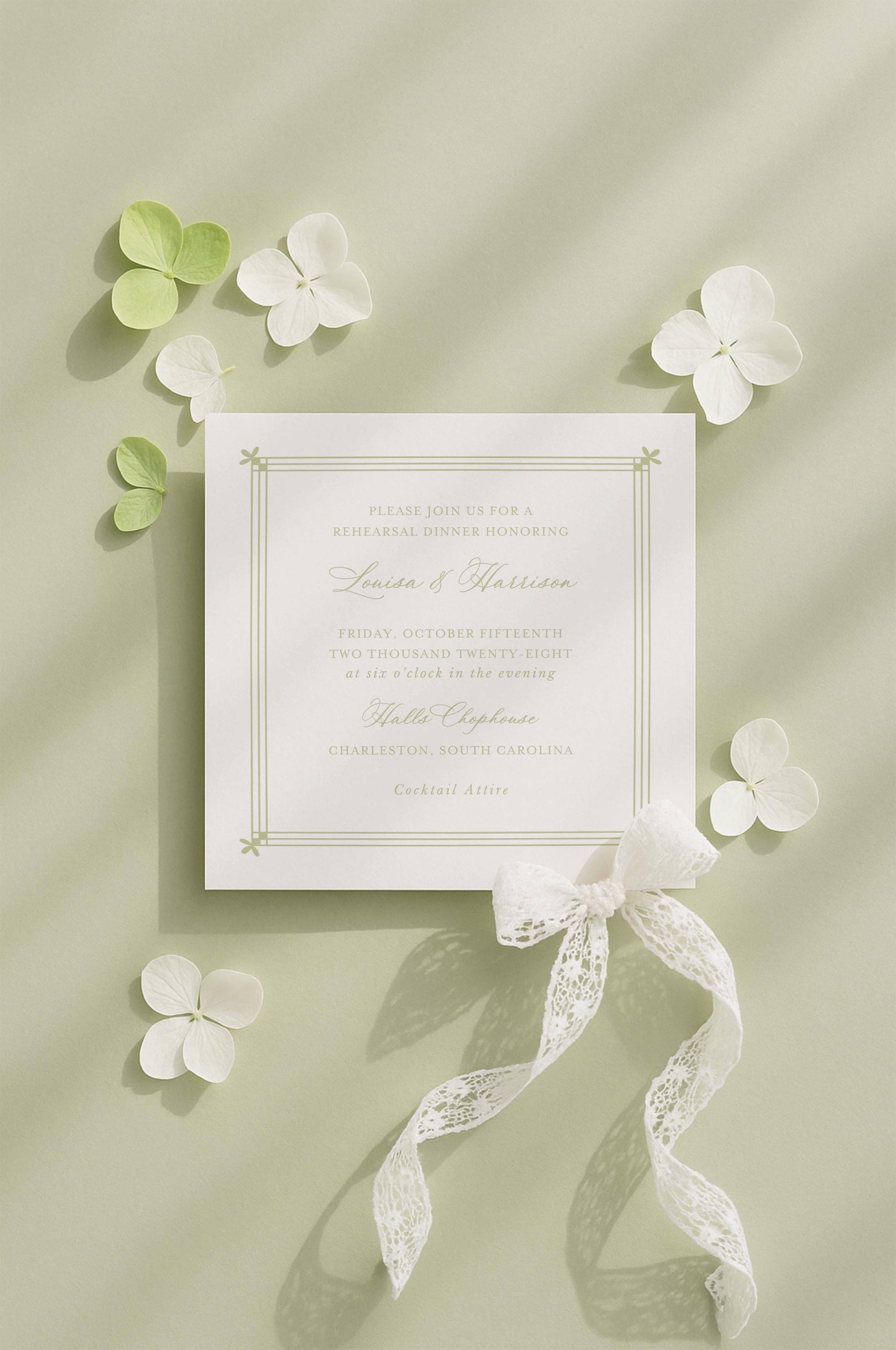 a formal invitation card with a white background and a white ribbon, surrounded by white flowers and leaves on a light green background.
