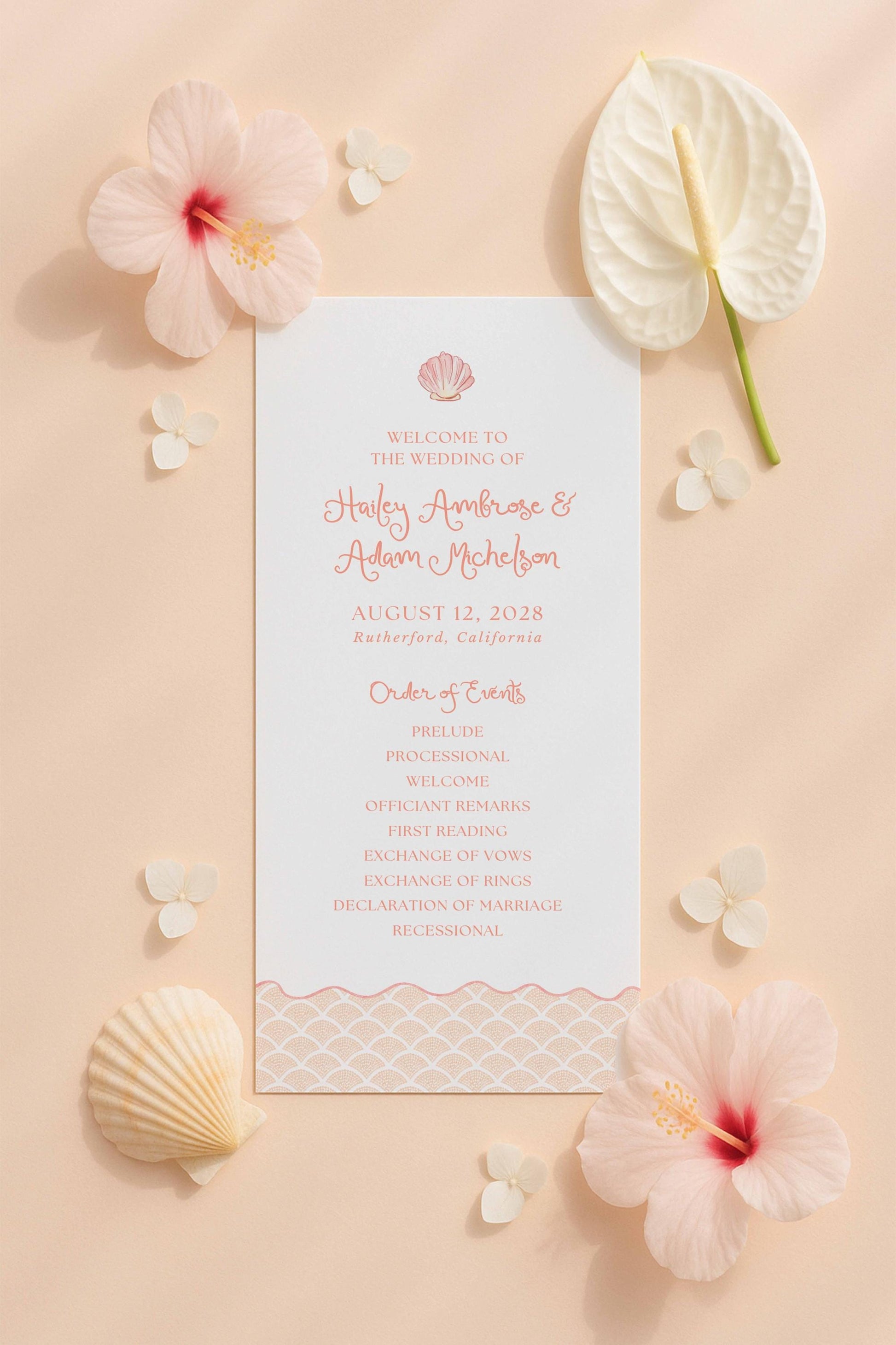 a wedding invitation card surrounded by various floral elements, including pink hibiscus flowers, white flowers, and seashells.