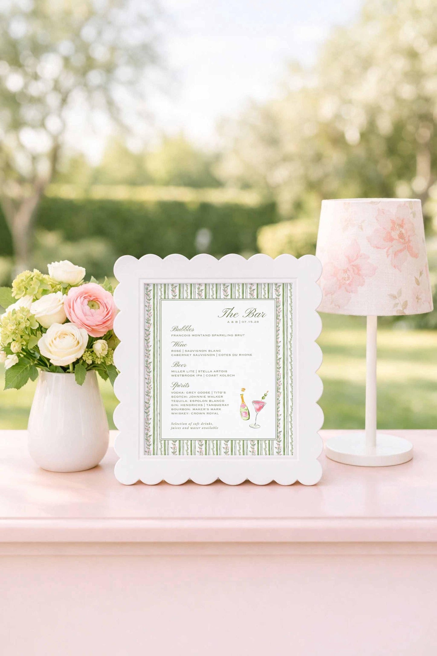 a white frame with a green and white striped border, displaying a menu or list of items, placed on a pink table next to a vase of flowers and a lamp.